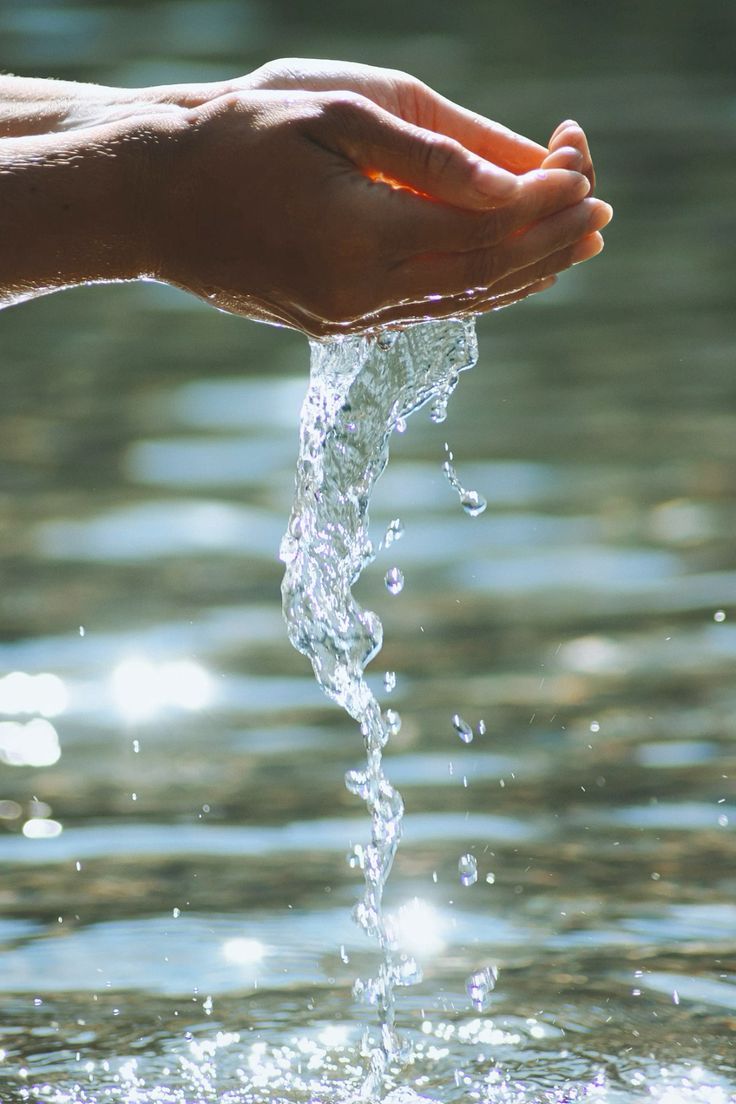 Hands gently cupping water in warm golden light